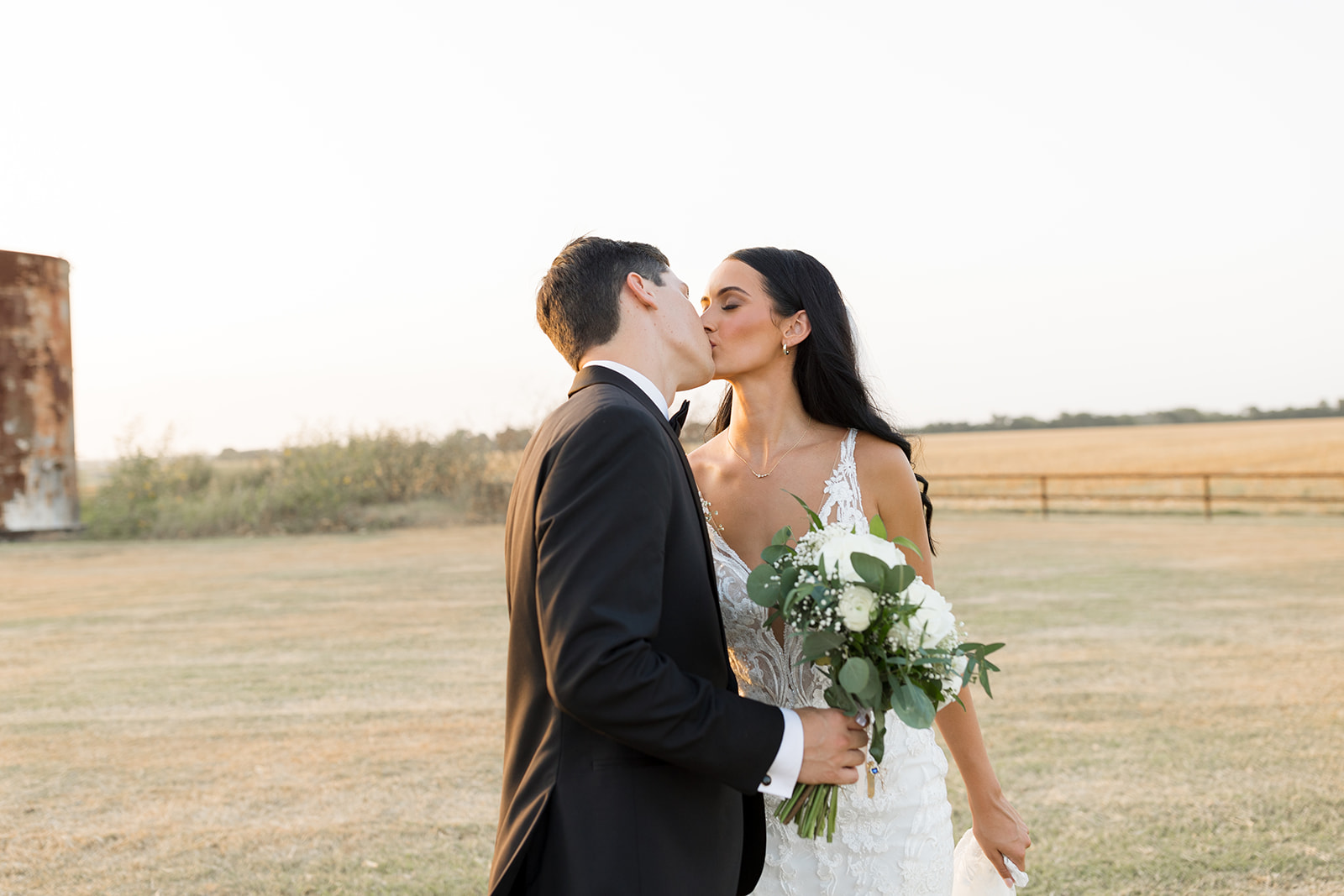 Bride and Groom kissing at an elegant rustic College Station wedding venue