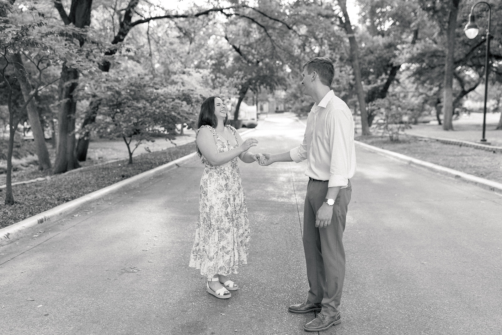 couple holding hands on a road for their engagement session at TWU in Denton, Texas