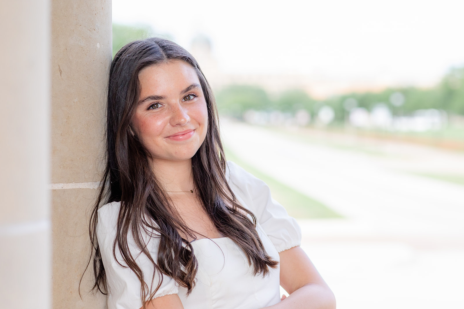 a senior posing for her grad session at the clock tower on the a&m campus