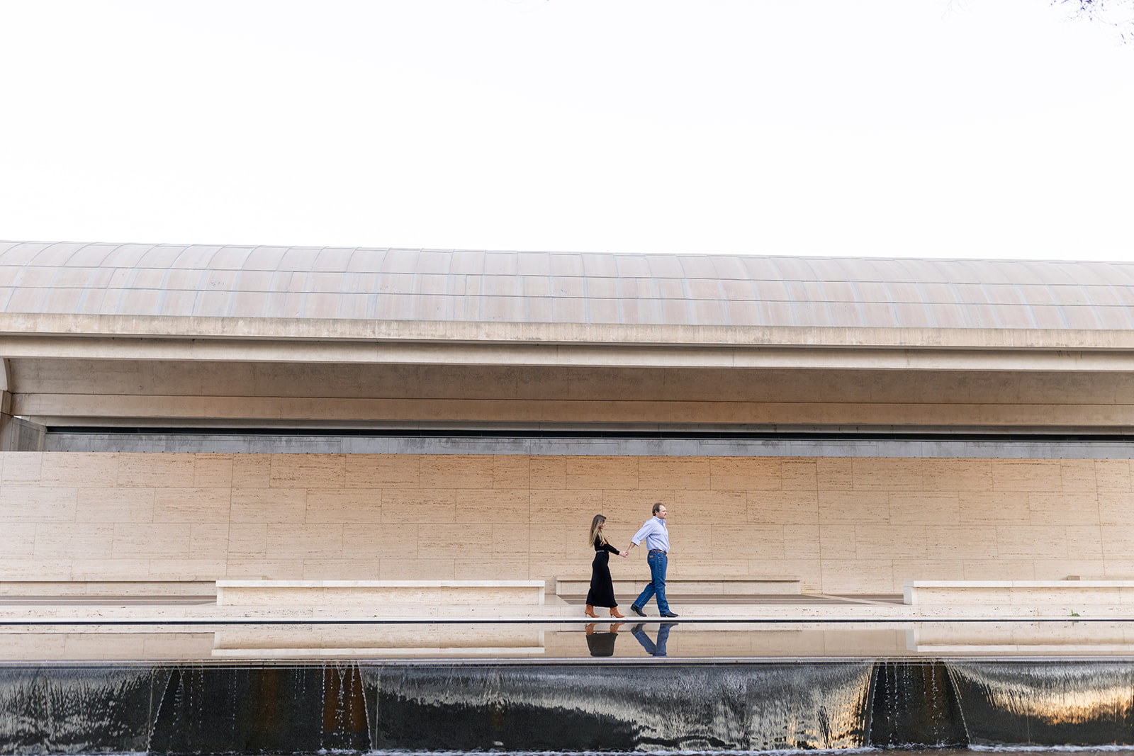 couple walking in front of water fall at a museum in Fort Worth Texas